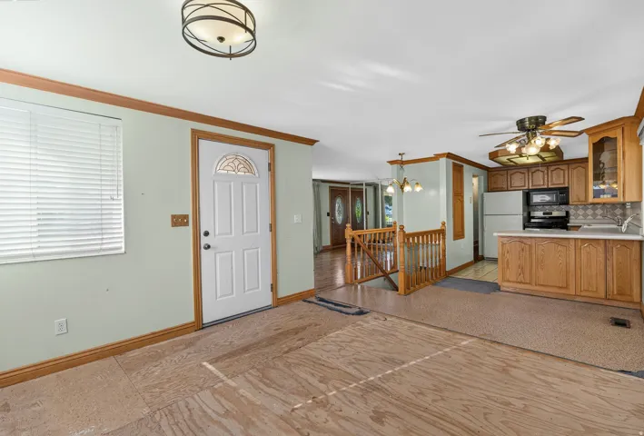 Kitchen area featuring wood-finish cabinetry, tile backsplash, and built-in appliances