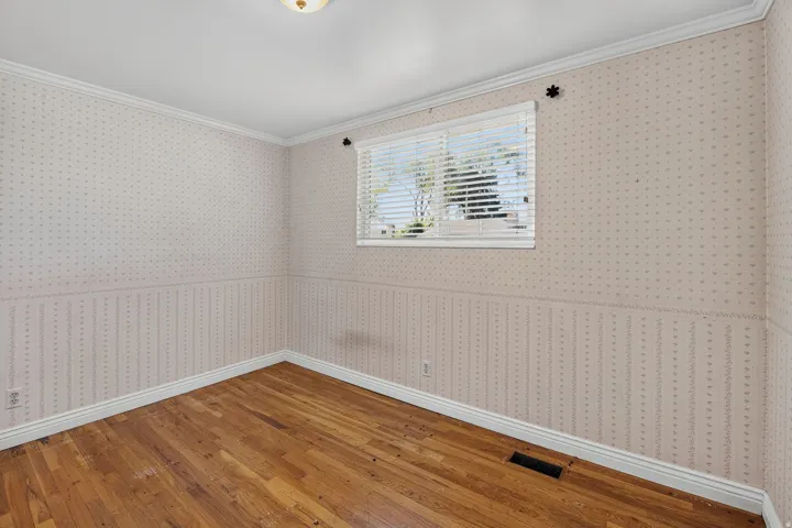 Wood-finish flooring, white window blinds, and a built-in ceiling light fixture