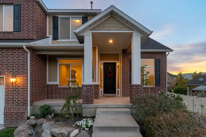 Brick exterior with siding accents, covered front porch, and a concrete pathway