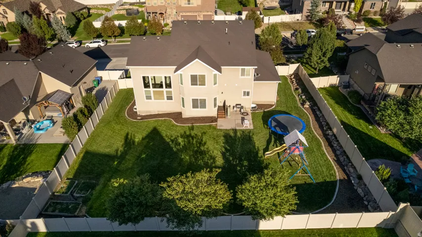Expansive backyard featuring a manicured lawn, established landscaping, and a multi-level deck