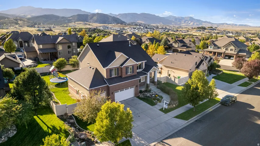 Two-story residential property featuring a multi-gable roof, an attached two-car garage, and a concrete driveway