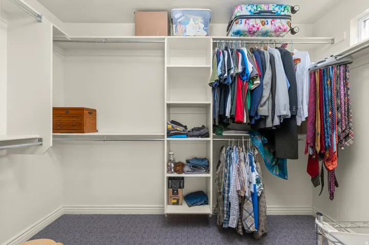 Custom closet system featuring built-in shelving, multiple hanging rods, and ample storage