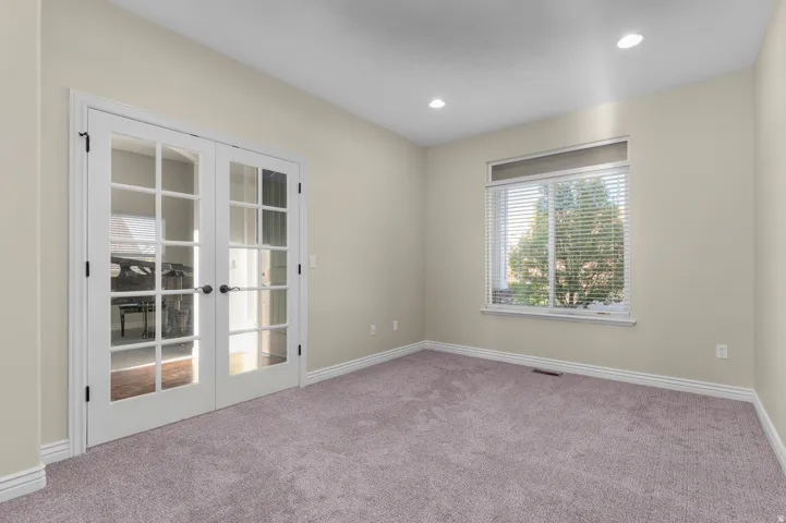 French doors with glass paneling, recessed ceiling lighting, a single window with blinds, and light-toned wall paint