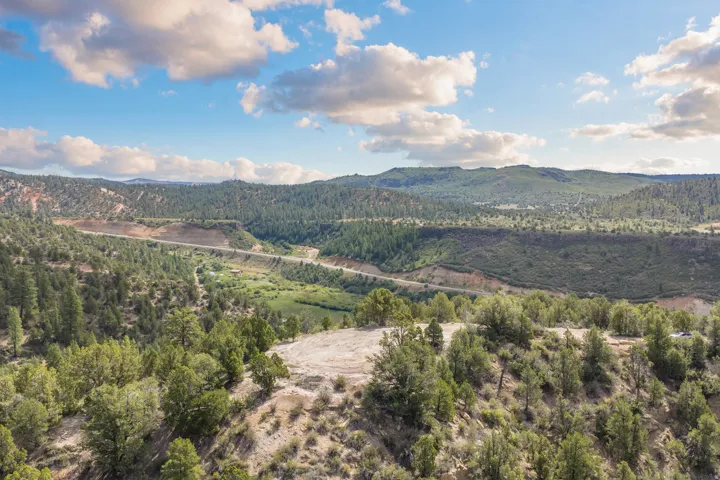 Expansive, undeveloped terrain featuring dense tree coverage and distant mountain ranges