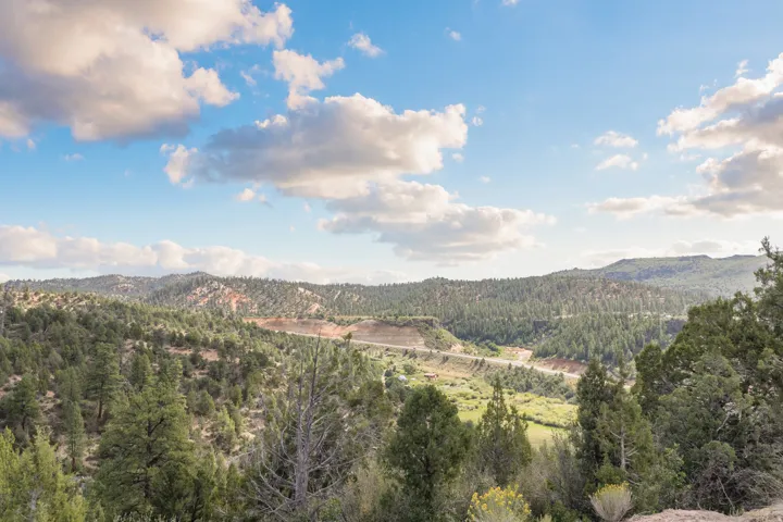 Scenic hillside setting with expansive vistas across forested terrain and rolling valleys