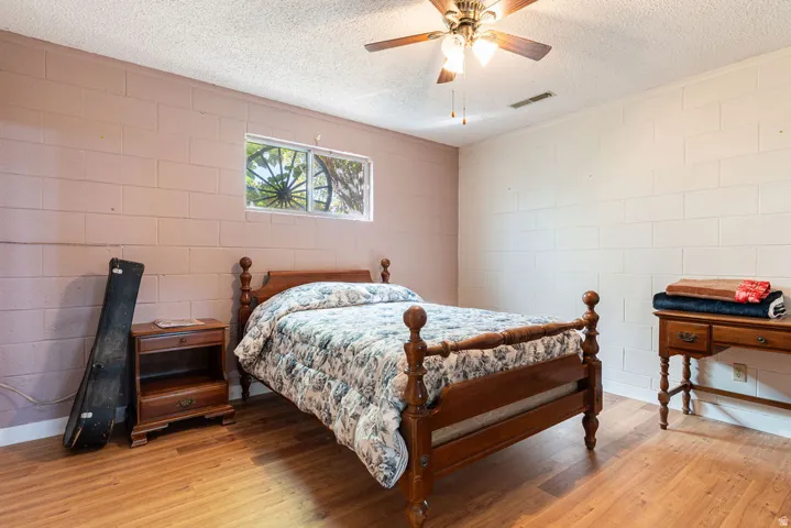Wood-finish flooring with a ceiling fan light fixture and a single window