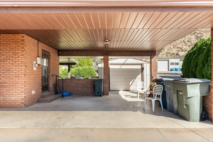 Covered concrete patio with brick wall surround