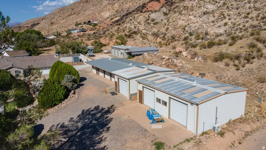 Two metal outbuildings featuring multiple overhead garage doors and corrugated metal roofs