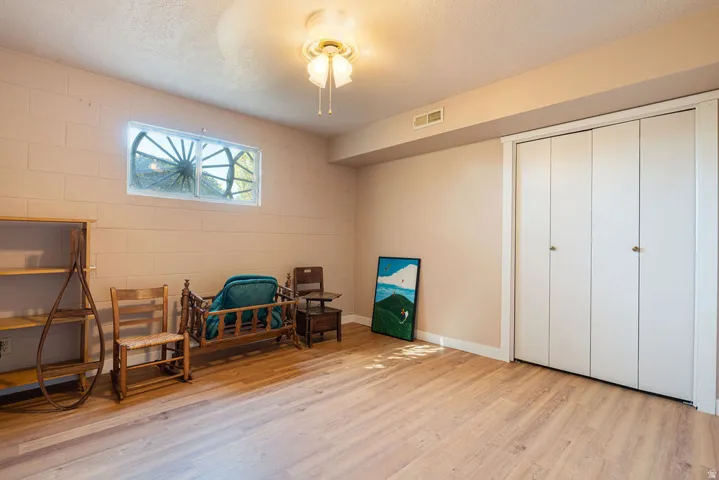 Wood-finish flooring, recessed window, bi-fold closet doors, and overhead lighting fixture