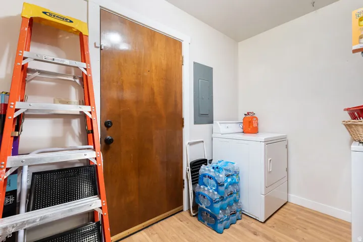 Wood-finish flooring, built-in electrical panel, and white walls