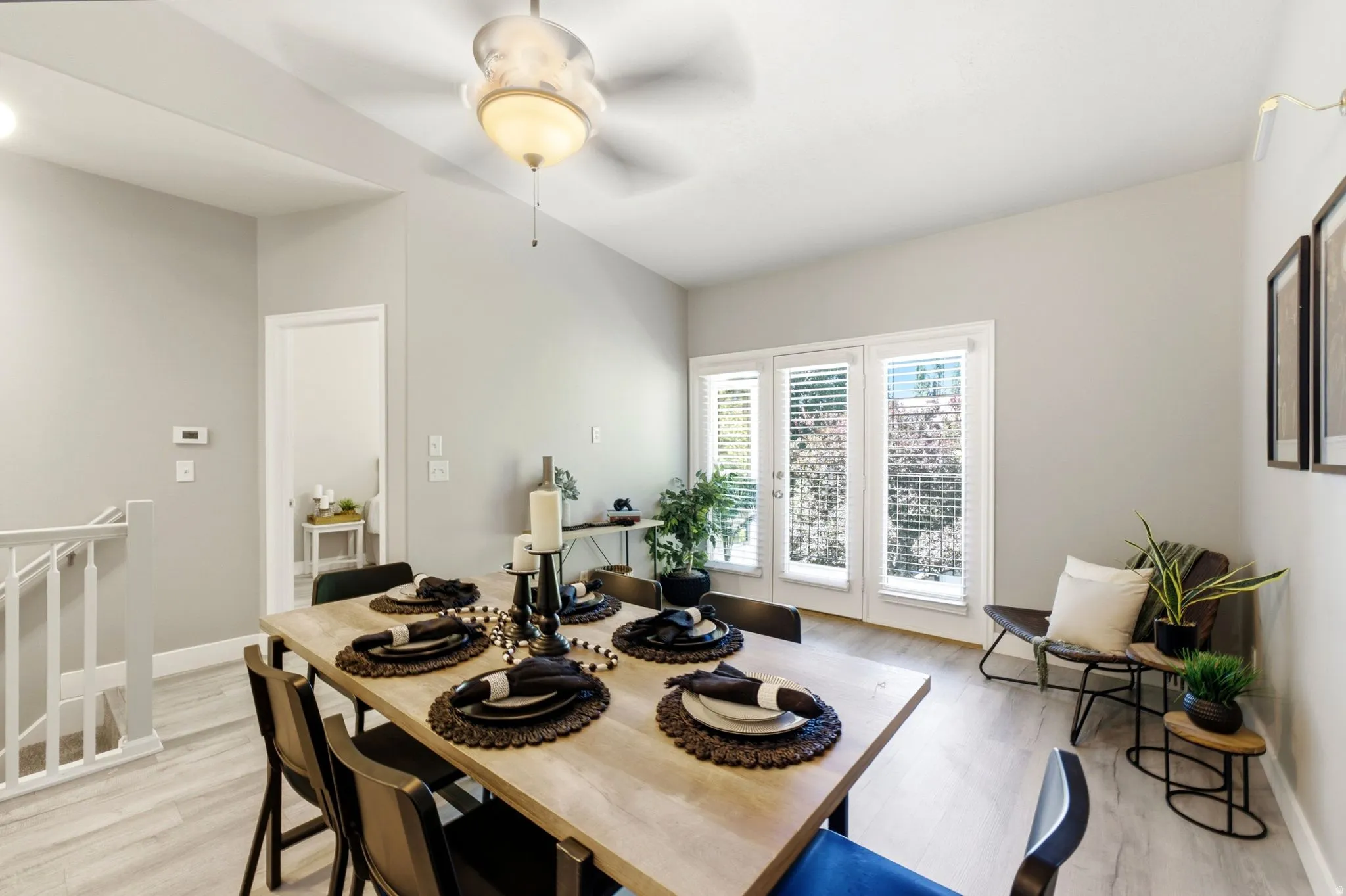 Light-toned flooring, vaulted ceiling, and white wall finishes