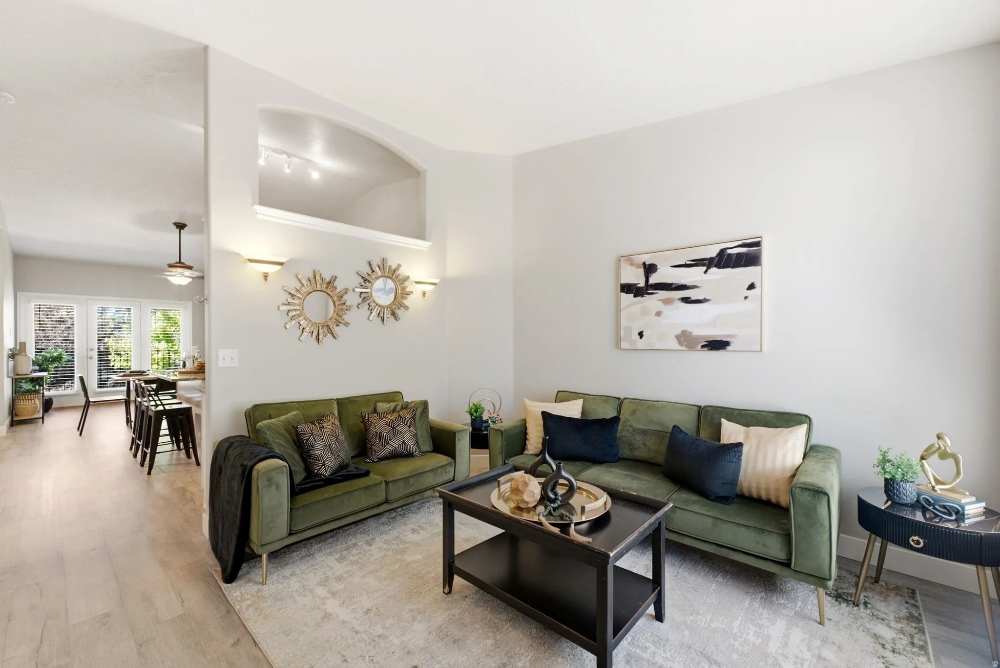 High ceilings, light wood-finish flooring, recessed wall niche, and built-in wall sconces