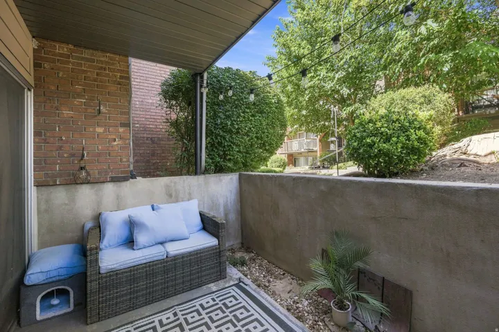 Covered outdoor patio with brick wall and gravel landscaping