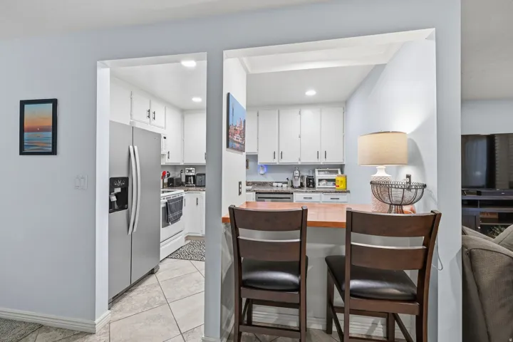 Kitchen featuring white cabinetry, light-toned countertops, and stainless steel appliances