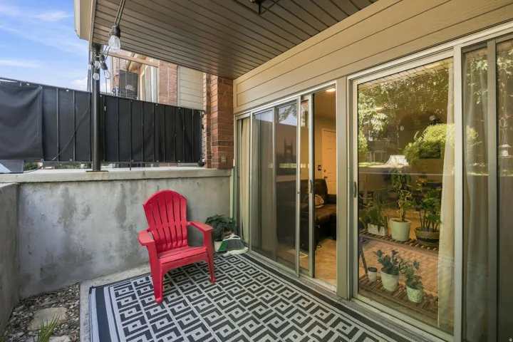 Covered patio featuring a concrete retaining wall, sliding glass doors, and string lighting