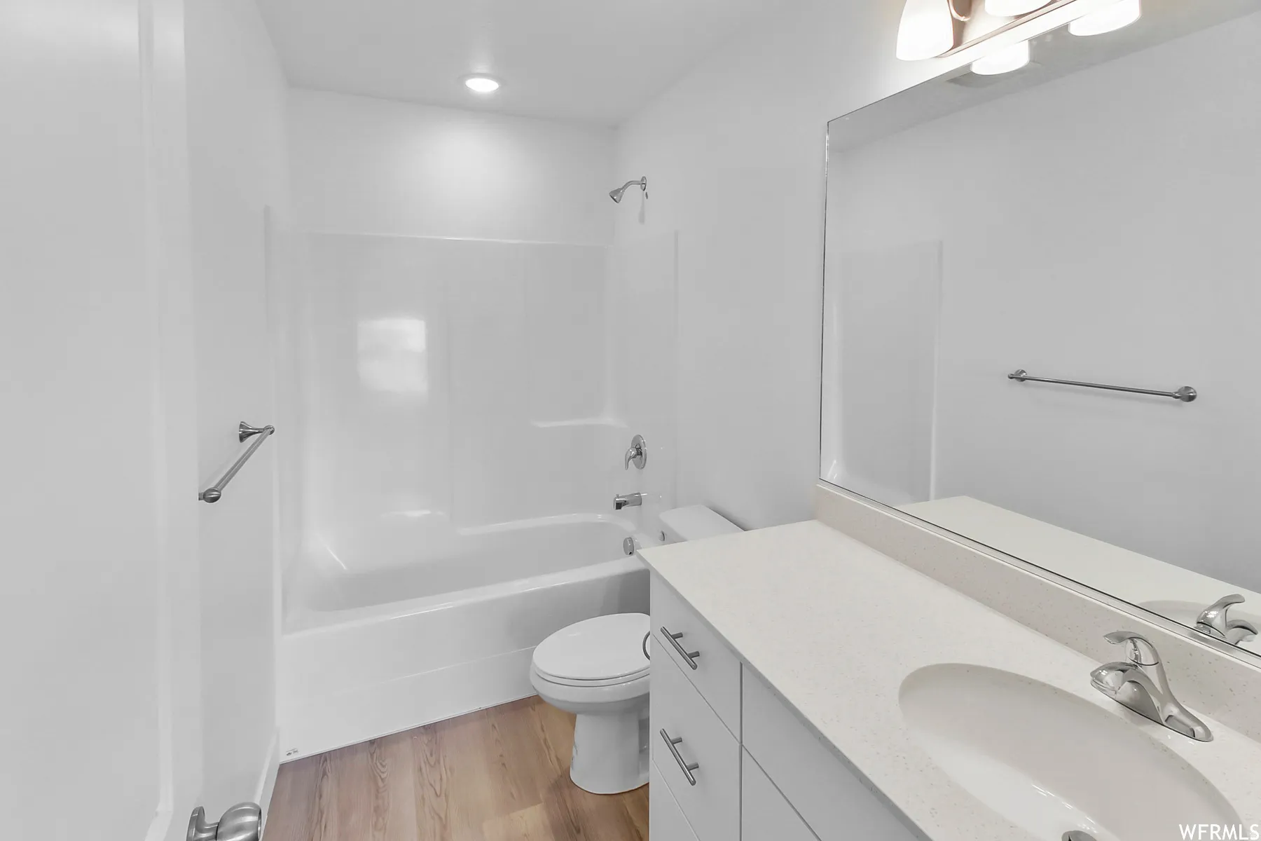 White vanity with a single basin, light-colored countertop, and chrome faucet