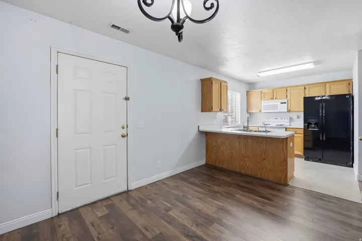 Kitchen with oak cabinetry, white countertops, and black appliances