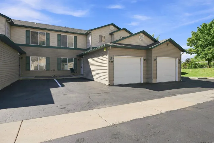 Multi-level exterior with horizontal siding, multiple windows with shutters, and two integrated single-car garages