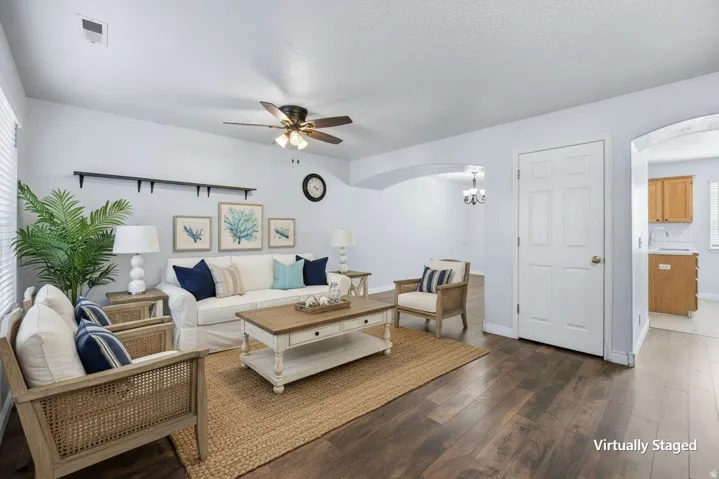 Virtually staged Living Room. Dark wood-finish flooring complements light-toned walls