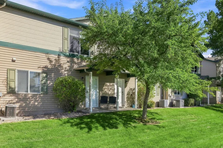 Manicured lawn, mature shade tree, and a covered patio entrance