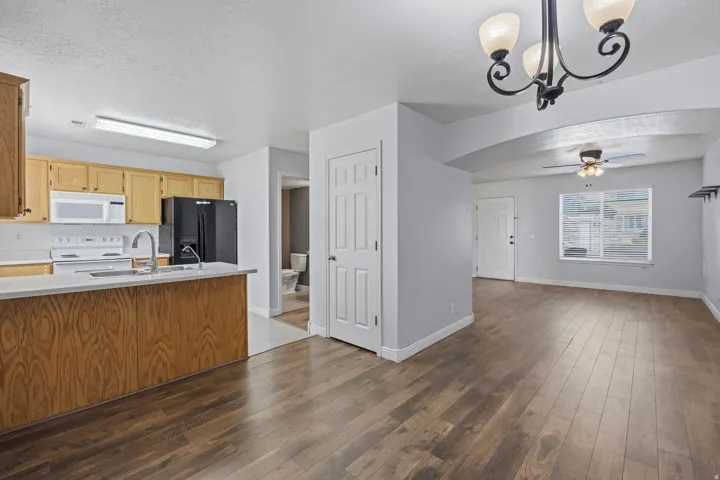 Kitchen featuring wood-finish cabinetry, white appliances, and a breakfast bar