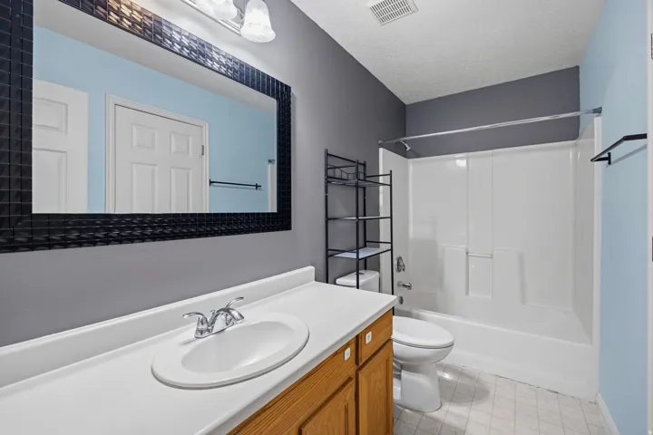 Bathroom vanity with wood-finish cabinetry and an integrated sink
