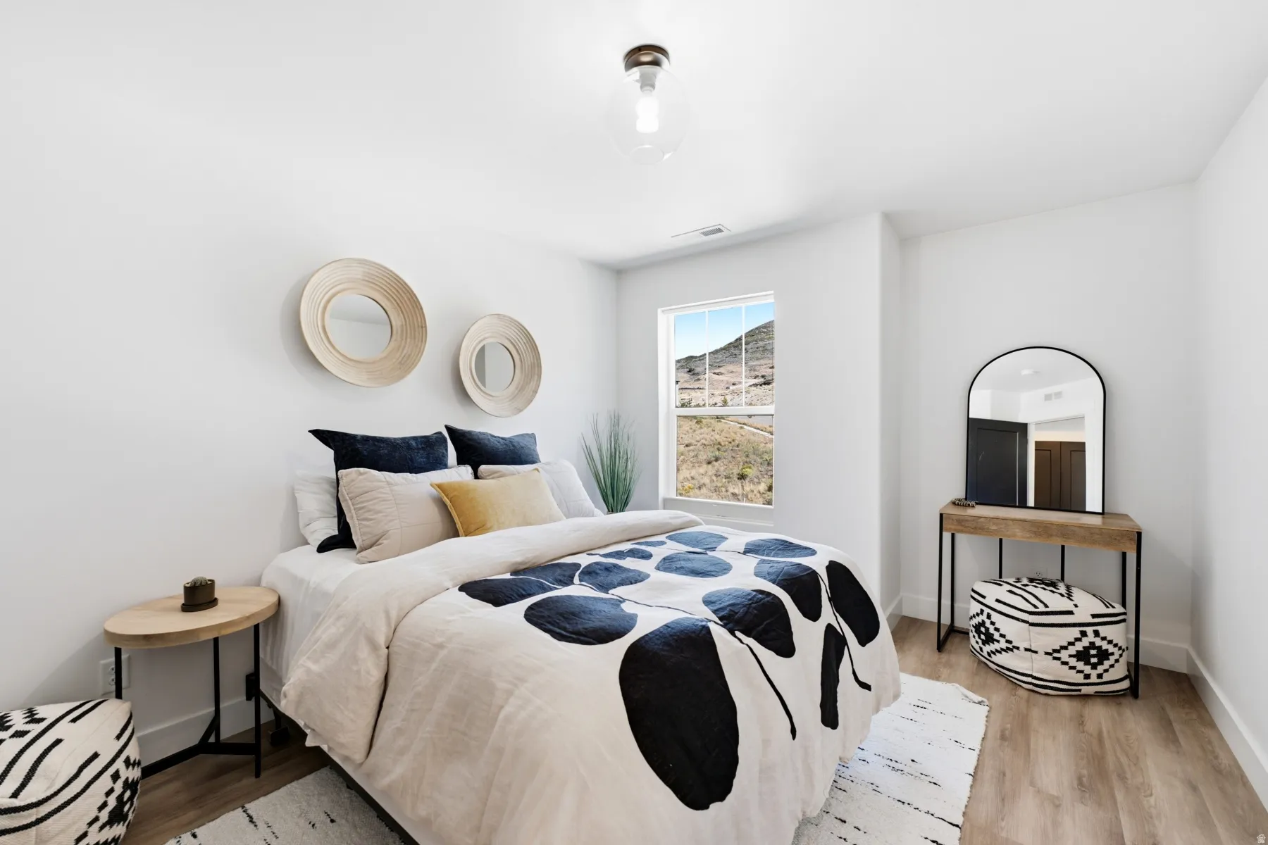 Recessed window with mountain backdrop, light wood-finish flooring, and a contemporary ceiling fixture