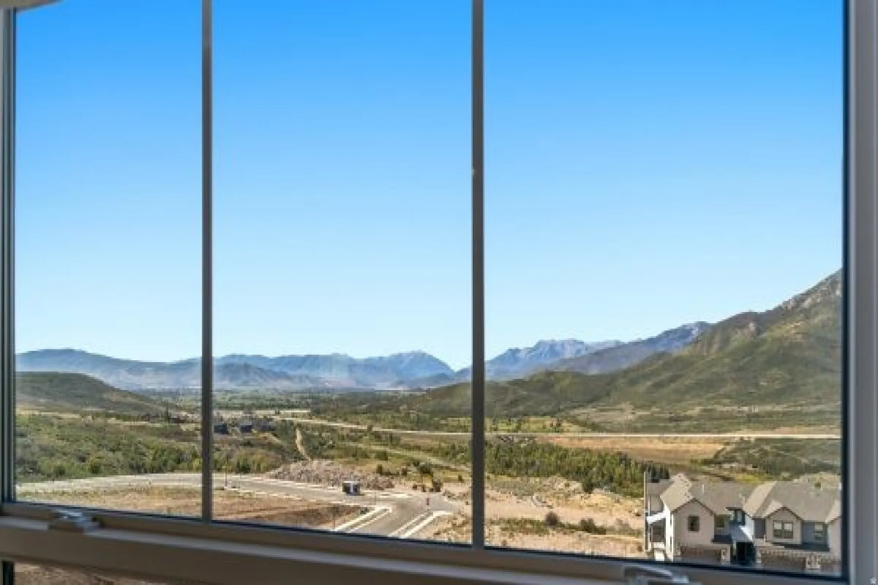 Expansive scenic view from primary bedroom featuring distant mountains and a broad valley