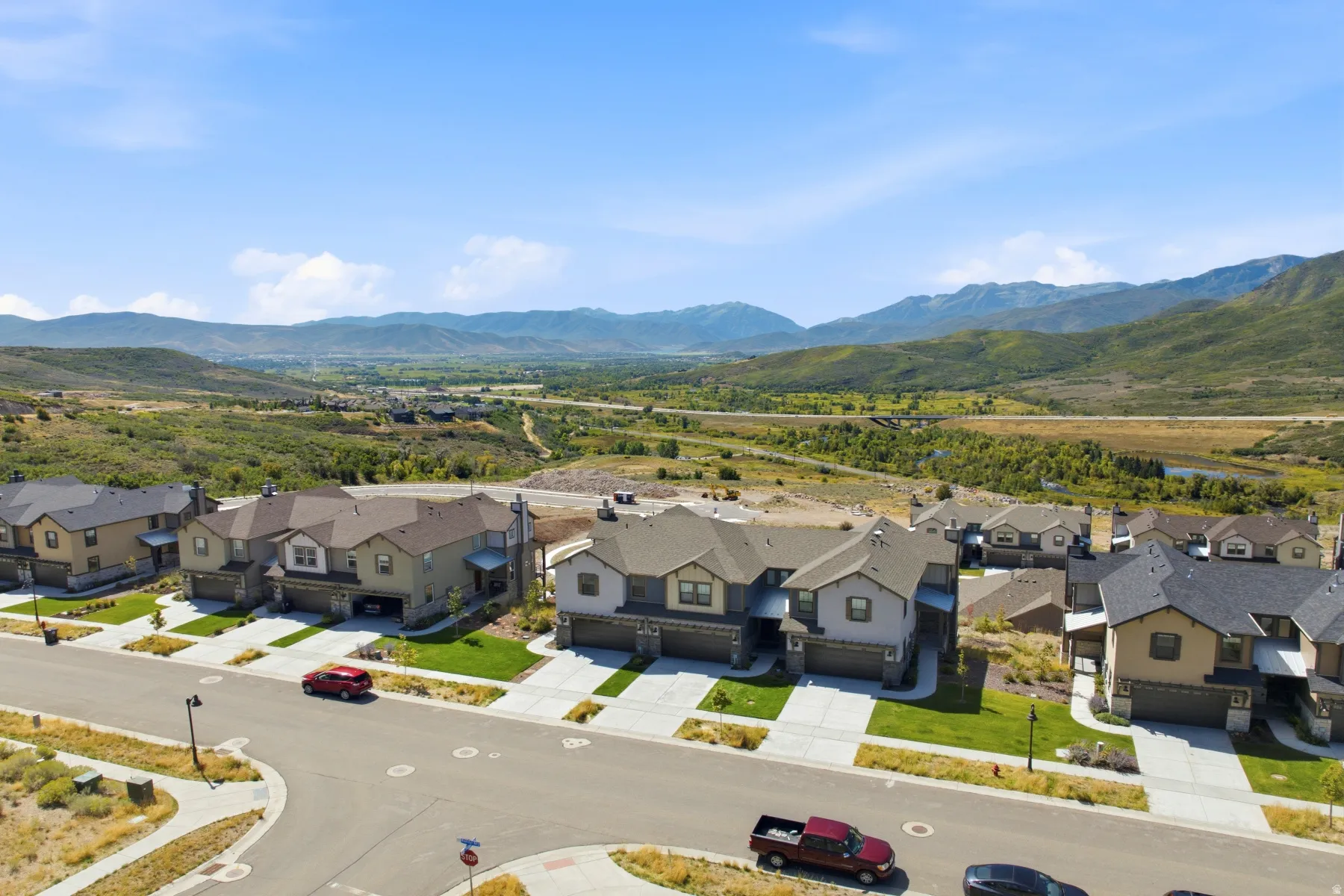 New construction homes with attached garages, manicured lawns, and paved driveways