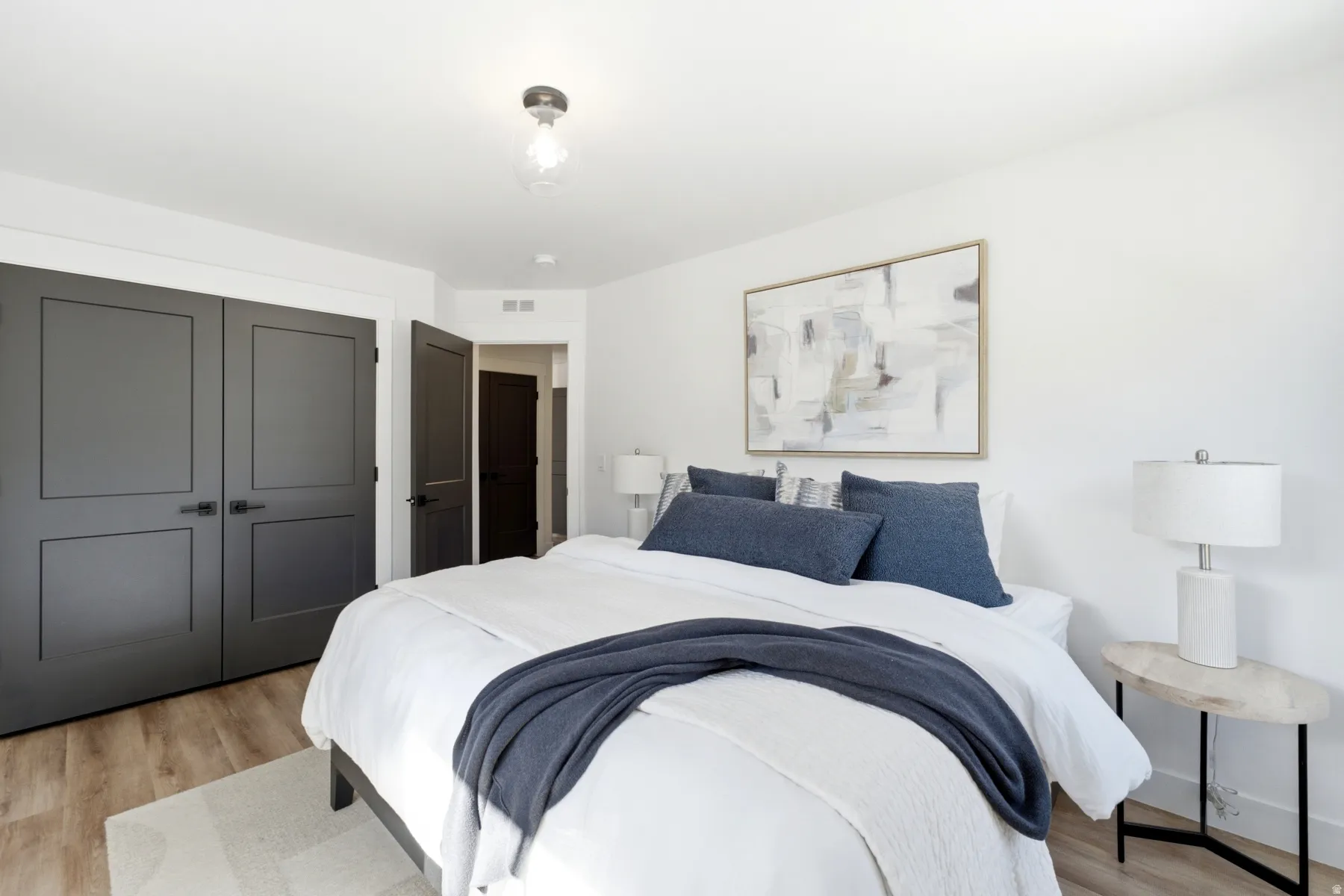 Wood-finish flooring, white walls, and a semi-flush mount ceiling fixture