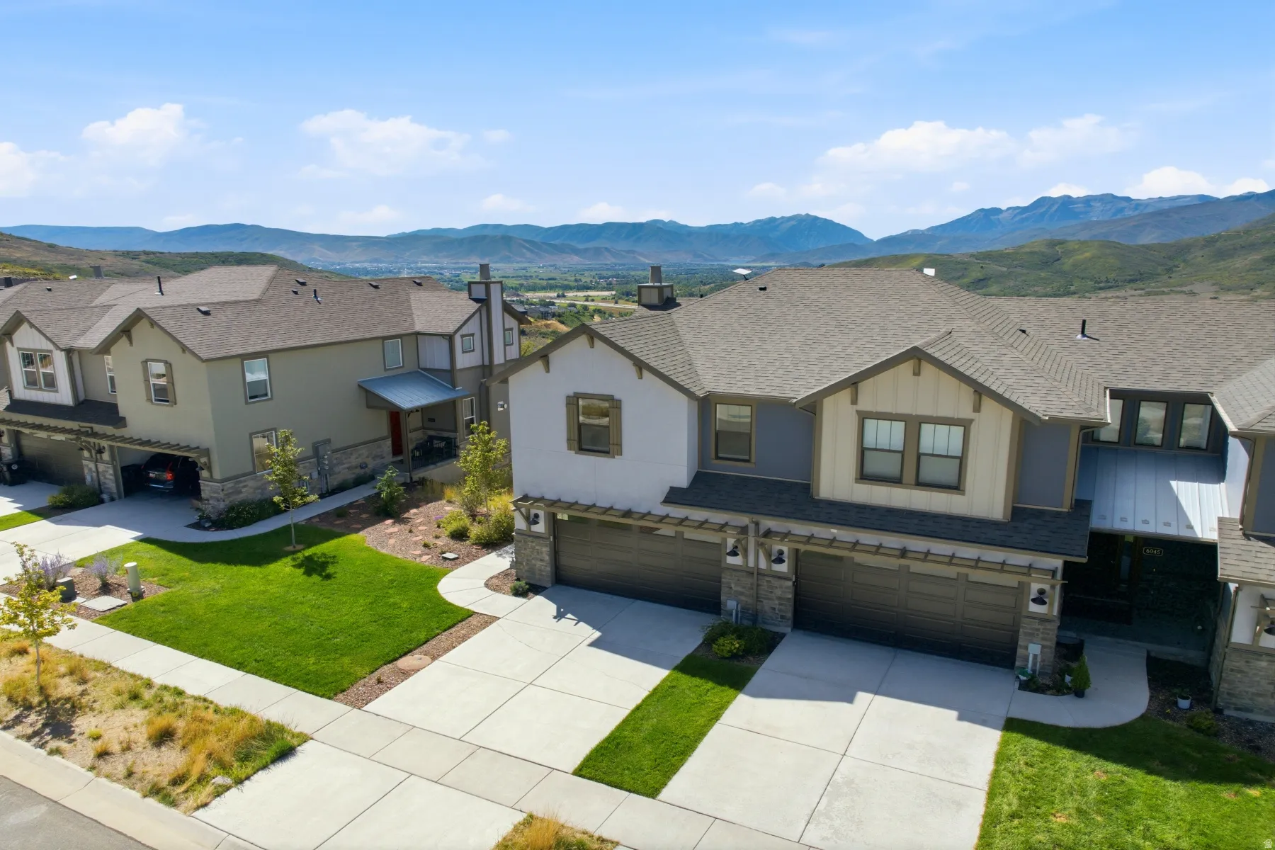 Modern exterior with multiple gables, stone accents, and a dual garage