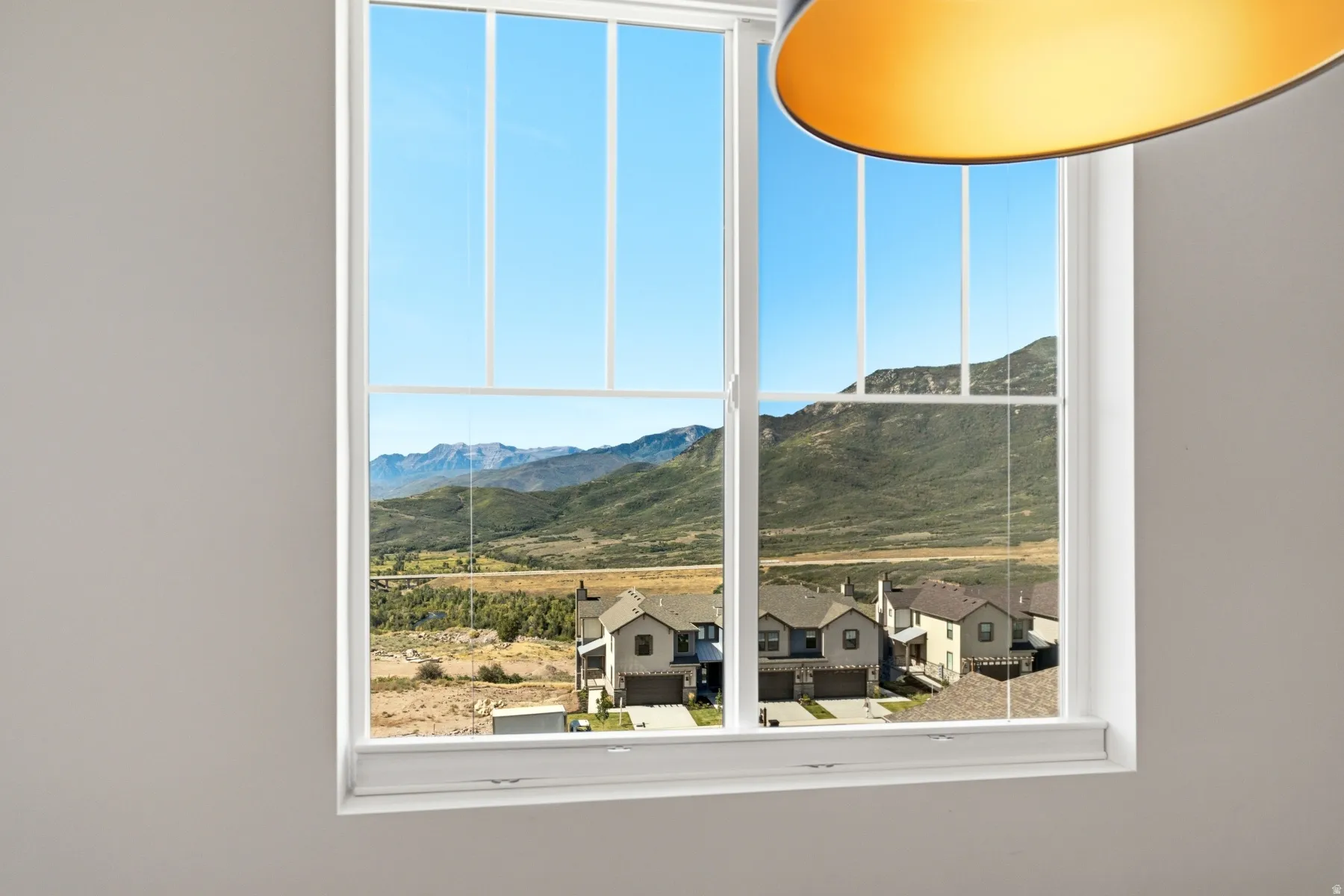 Double-hung window framing a mountainous landscape