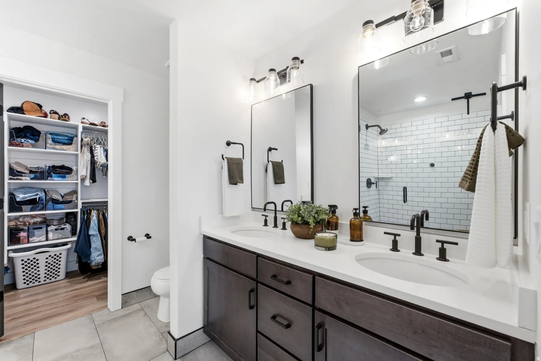 Dual vanity with white countertops and dark wood-finish cabinetry