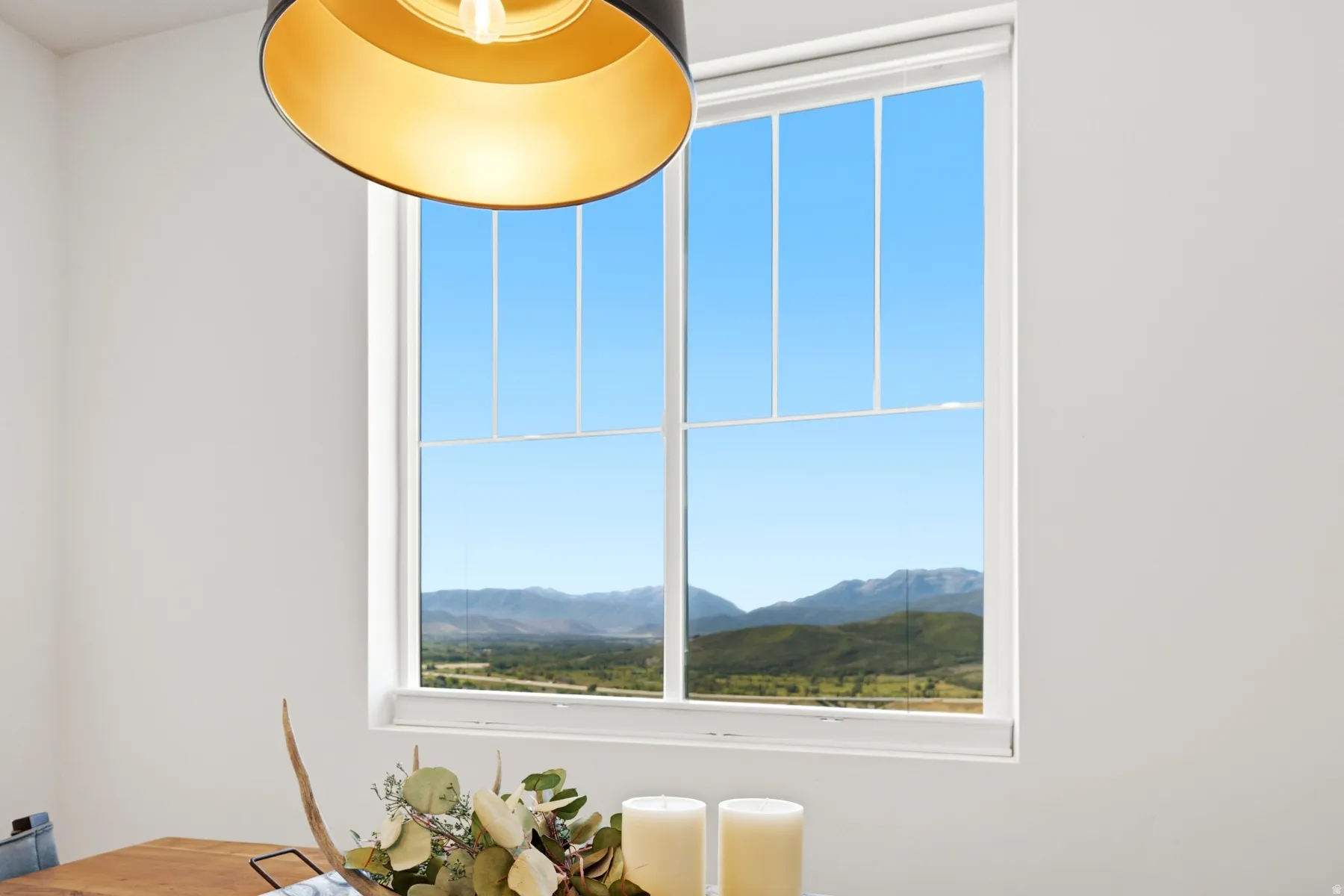 White-framed window with muntins providing expansive mountain and valley scenery