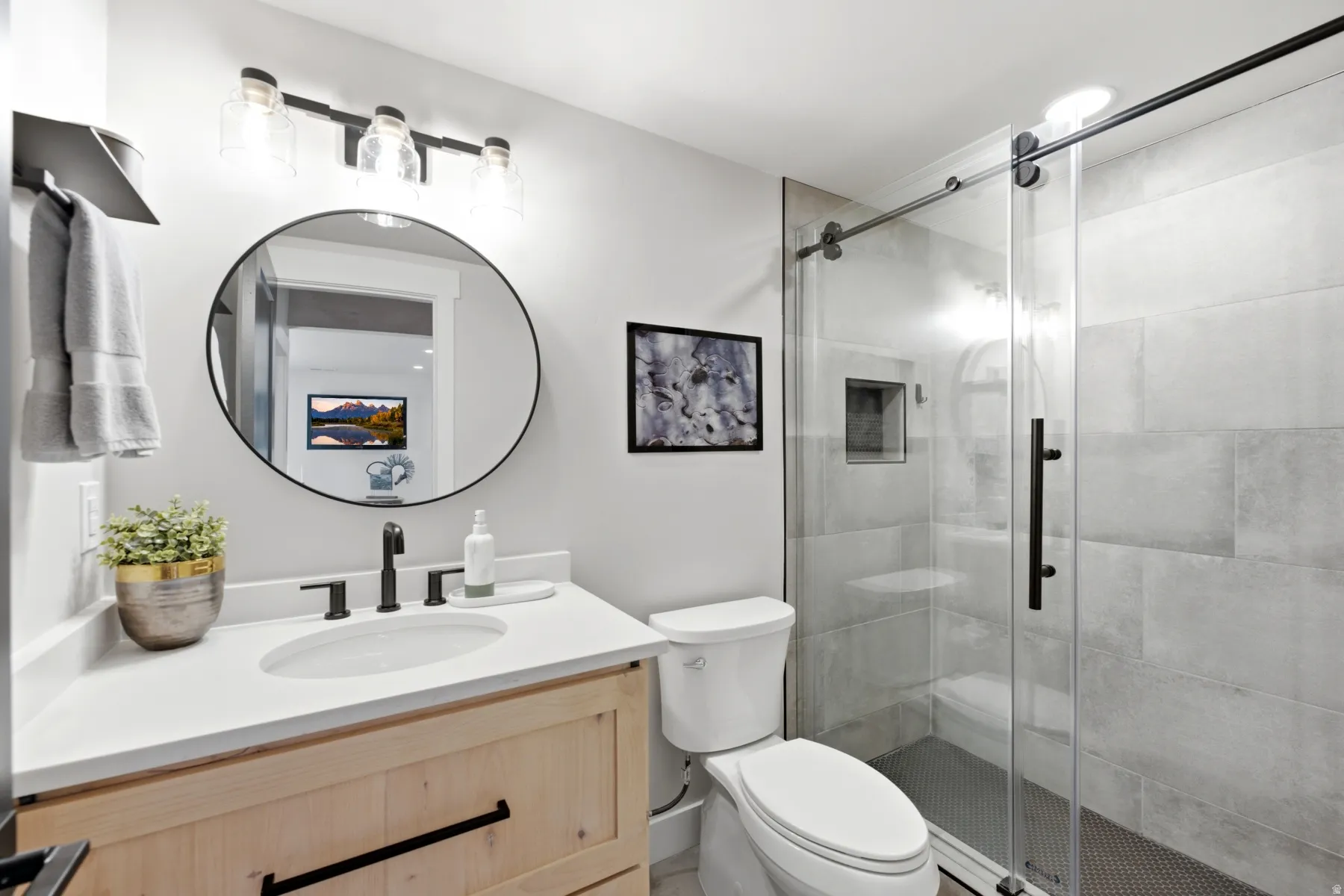 Natural wood-finish vanity with a white countertop and undermount sink