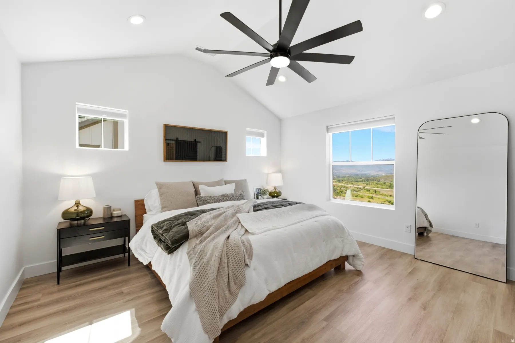 Vaulted ceiling, recessed lighting, wood-finish flooring, large window, and ceiling fan with black blades