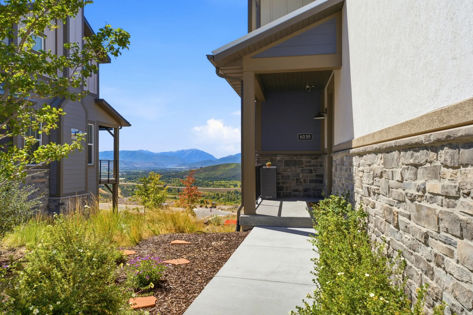 Stucco and stone veneer exterior with a covered entry