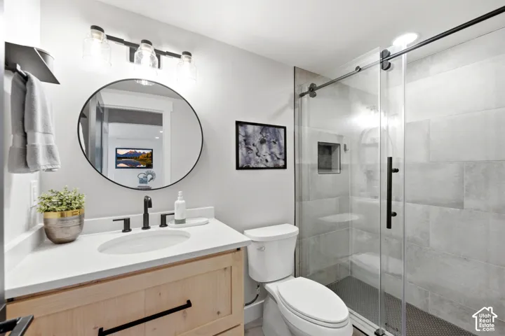 Natural wood-finish vanity with a white countertop and undermount sink