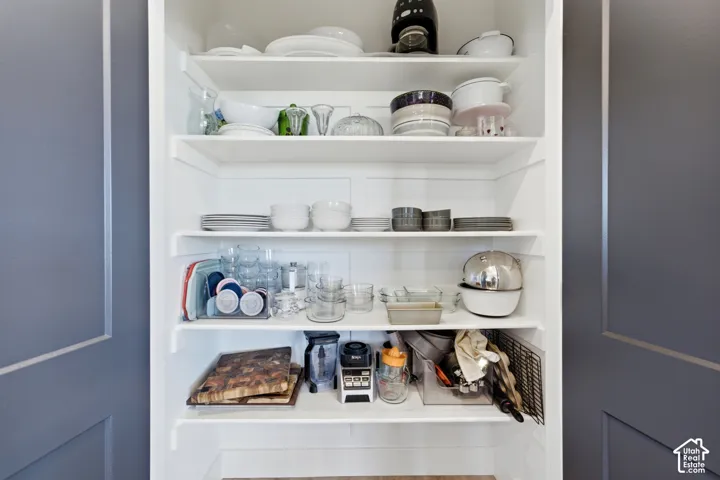 Built-in white shelving system with multiple tiers, set within a recessed alcove