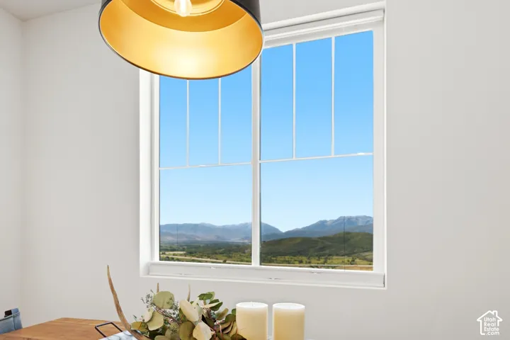 White-framed window with muntins providing expansive mountain and valley scenery