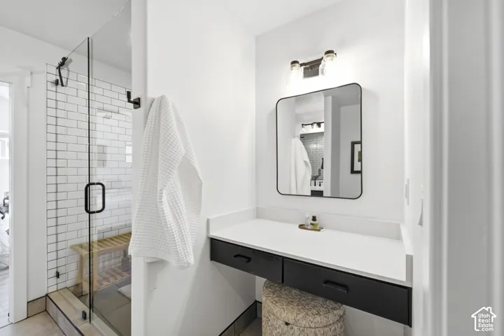 Glass-enclosed shower with subway tile surround and built-in bench