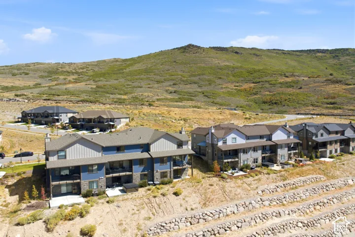Contemporary multi-story residences featuring balconies, patios, and a stone retaining wall system