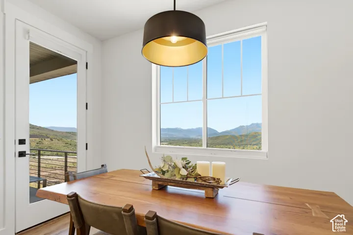 Expansive window with mountain scenery, direct outdoor access, and a dark-toned pendant light fixture