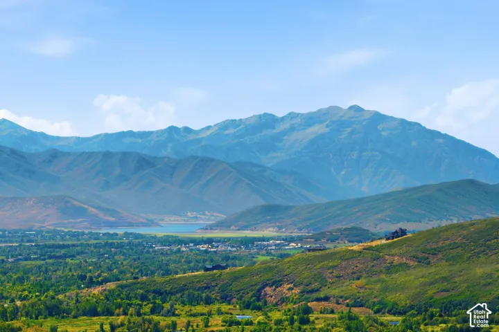 Expansive mountain scenery with distant water feature and lush green foothills