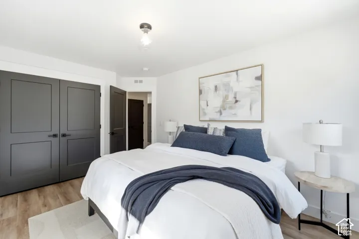 Wood-finish flooring, white walls, and a semi-flush mount ceiling fixture