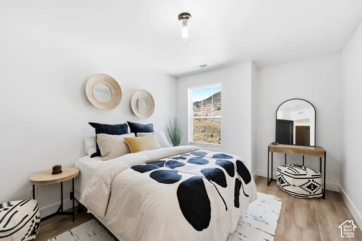 Recessed window with mountain backdrop, light wood-finish flooring, and a contemporary ceiling fixture