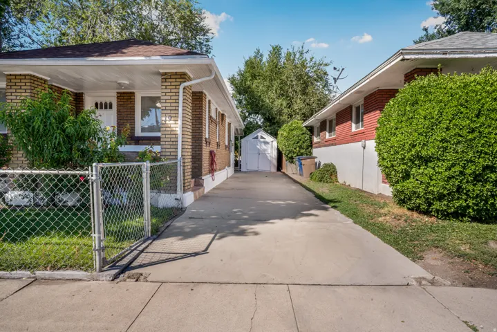 Paved driveway providing access to a white storage shed