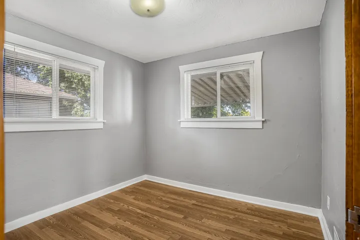 Wood-finish flooring with white trim and grey walls