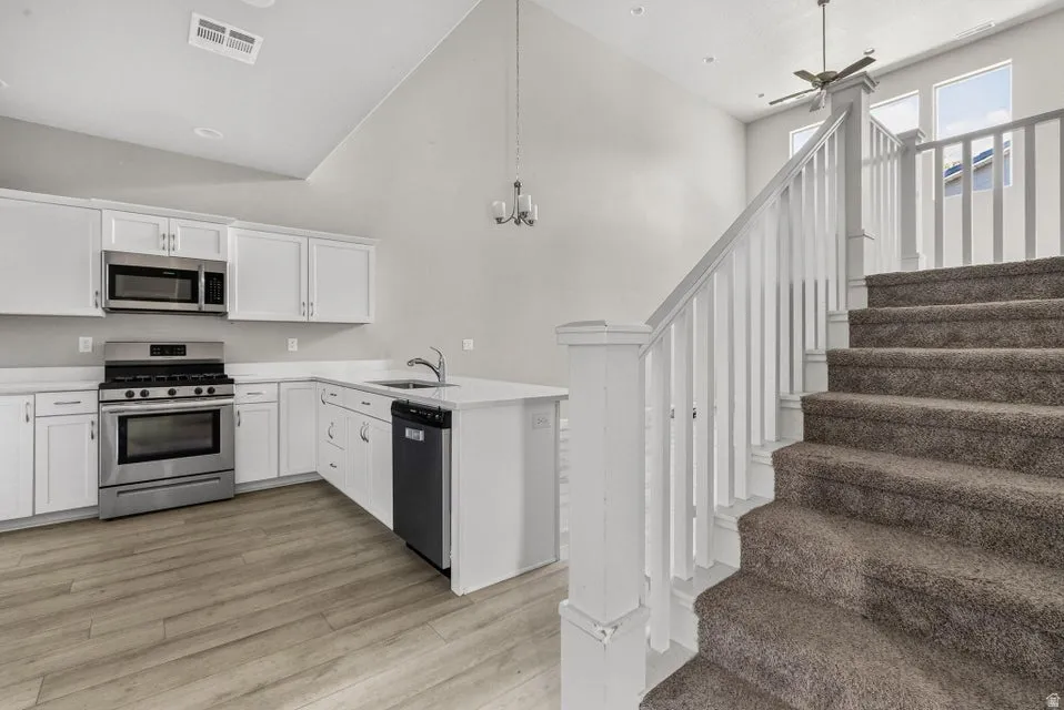 Kitchen with white cabinetry, stainless steel appliances, and a central island