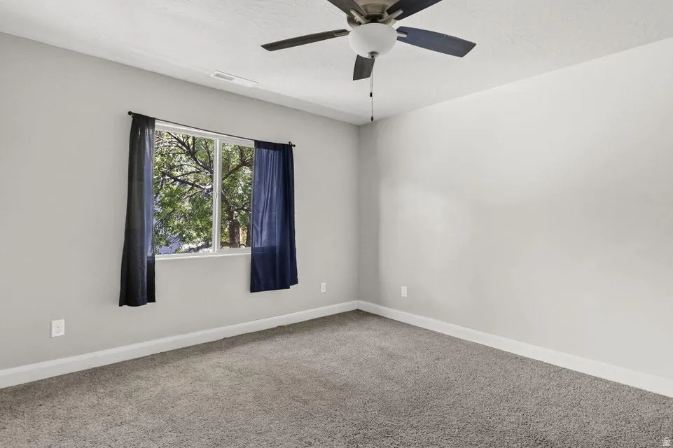 Neutral-toned walls, gray carpeting, and a white window frame